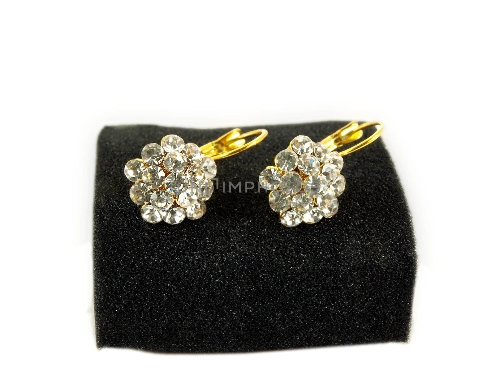 Diamond earrings on black sponge, isolated towards white background