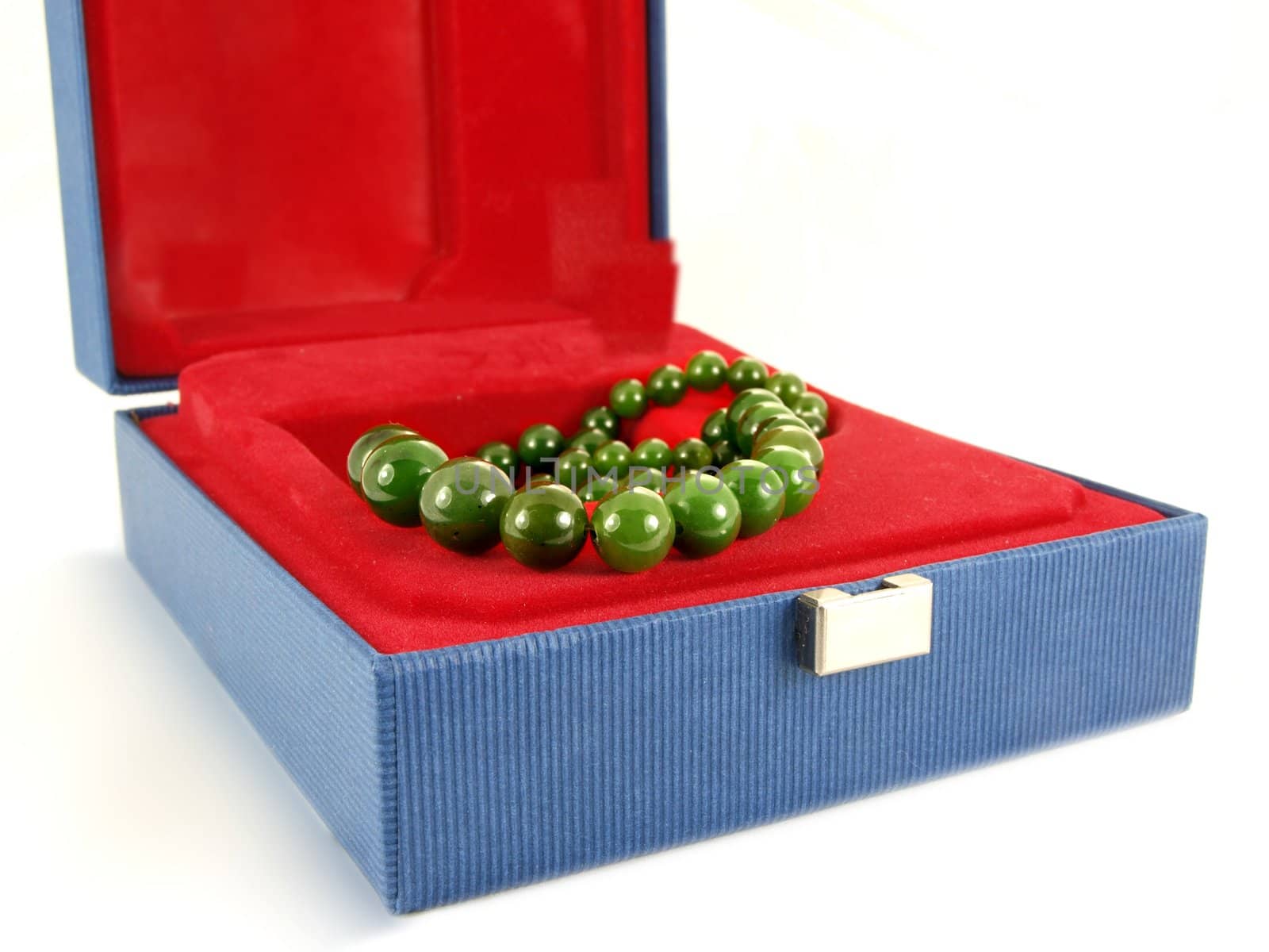 Green gemstone necklace, inside a jewelry box, isolated towards white background