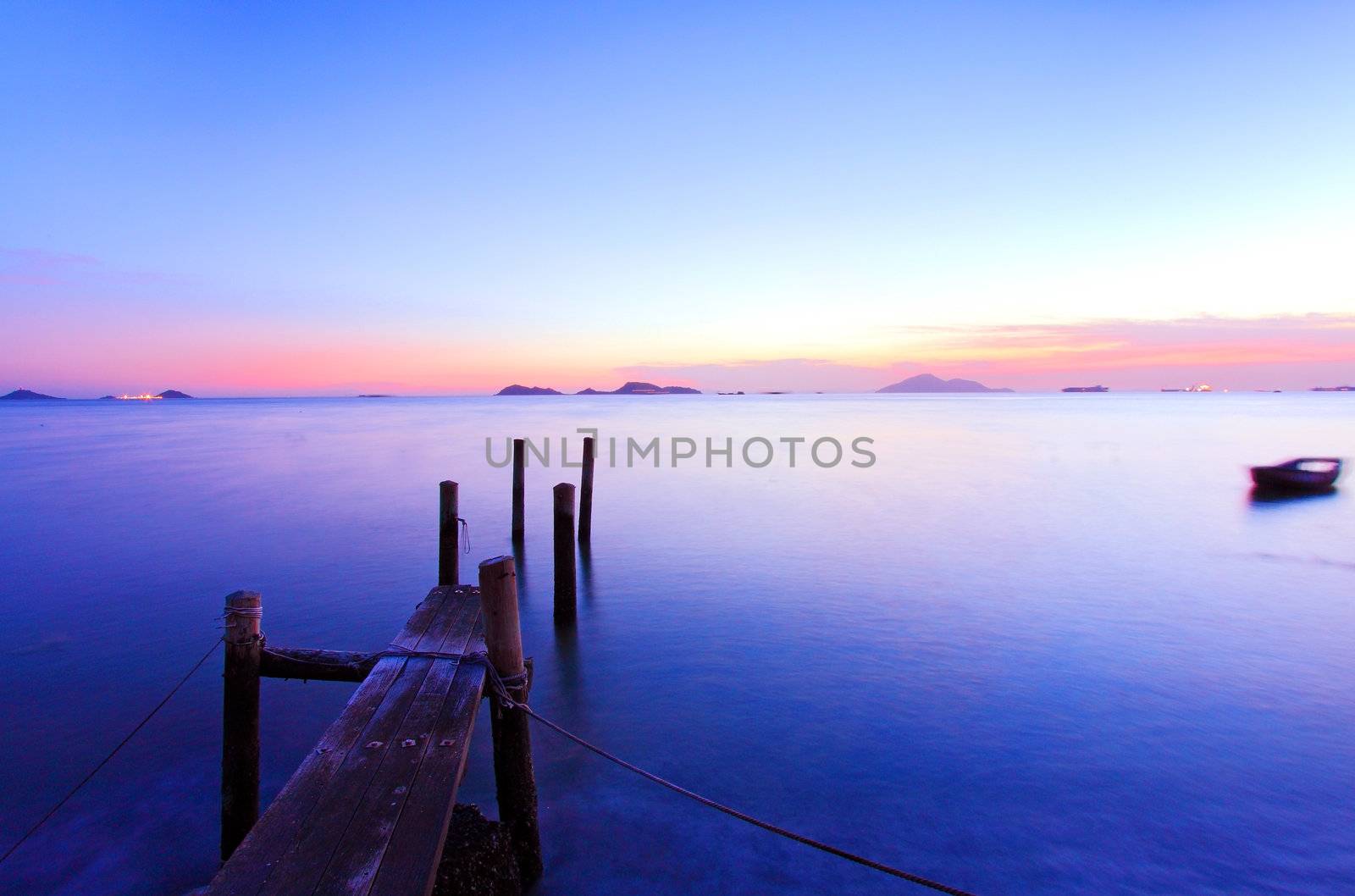 Sunset along a wooden pier at magic hour by kawing921