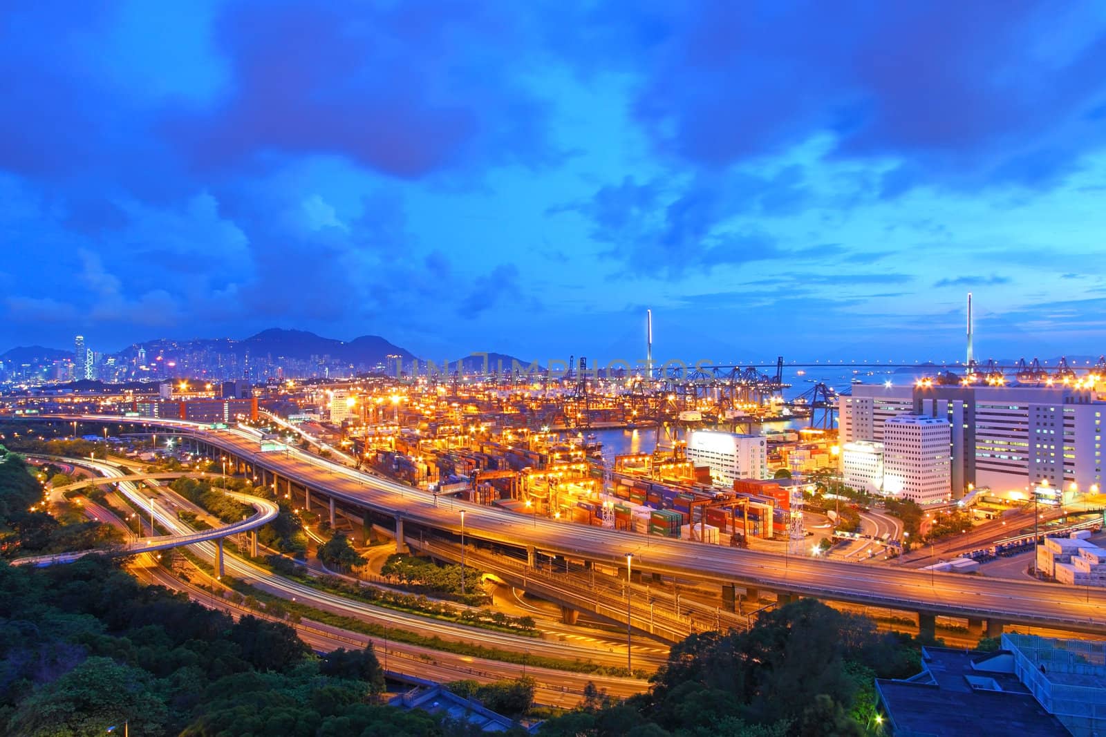 Traffic in Hong Kong at night, with container terminal background. 