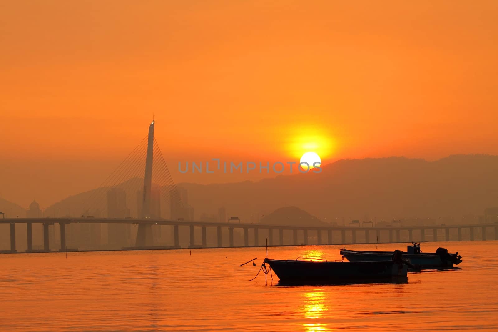 Sunset in Hong Kong along the coast, with many boats showing the fishing village background here.