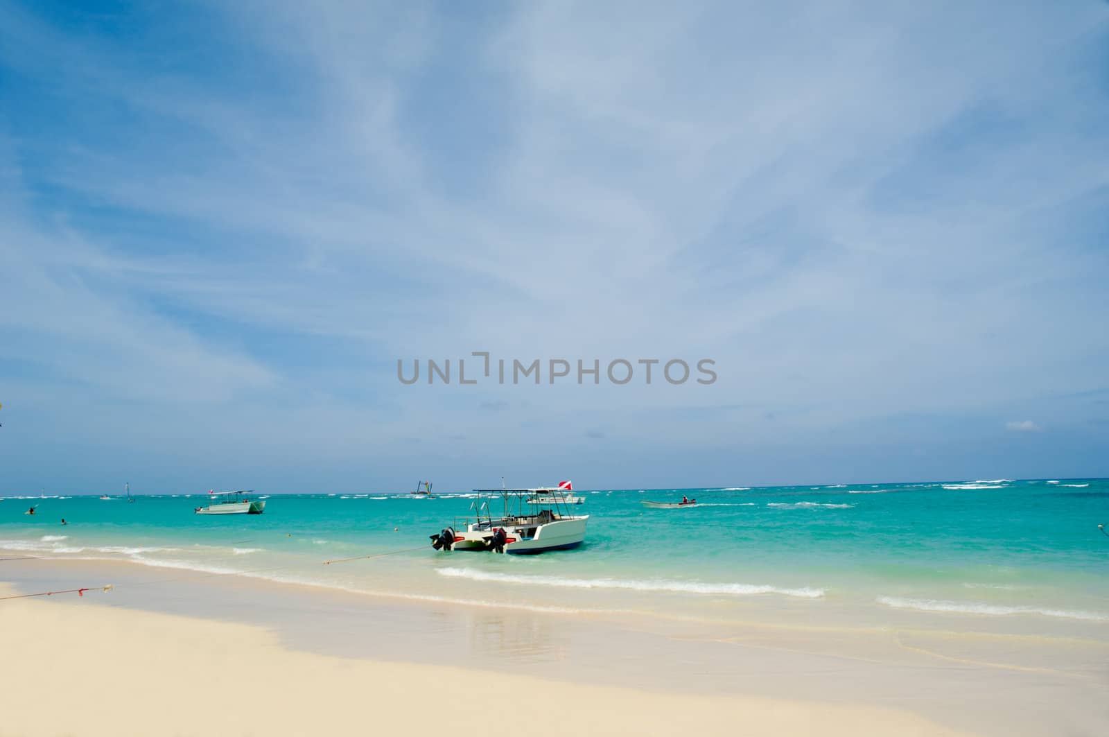 Exotic beach with white sand. In the water you can see some boats. Dominican Republic, Punta Cana.