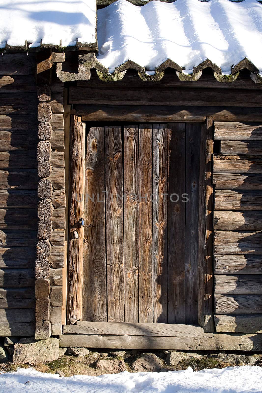 Old wooden door with snowy roof