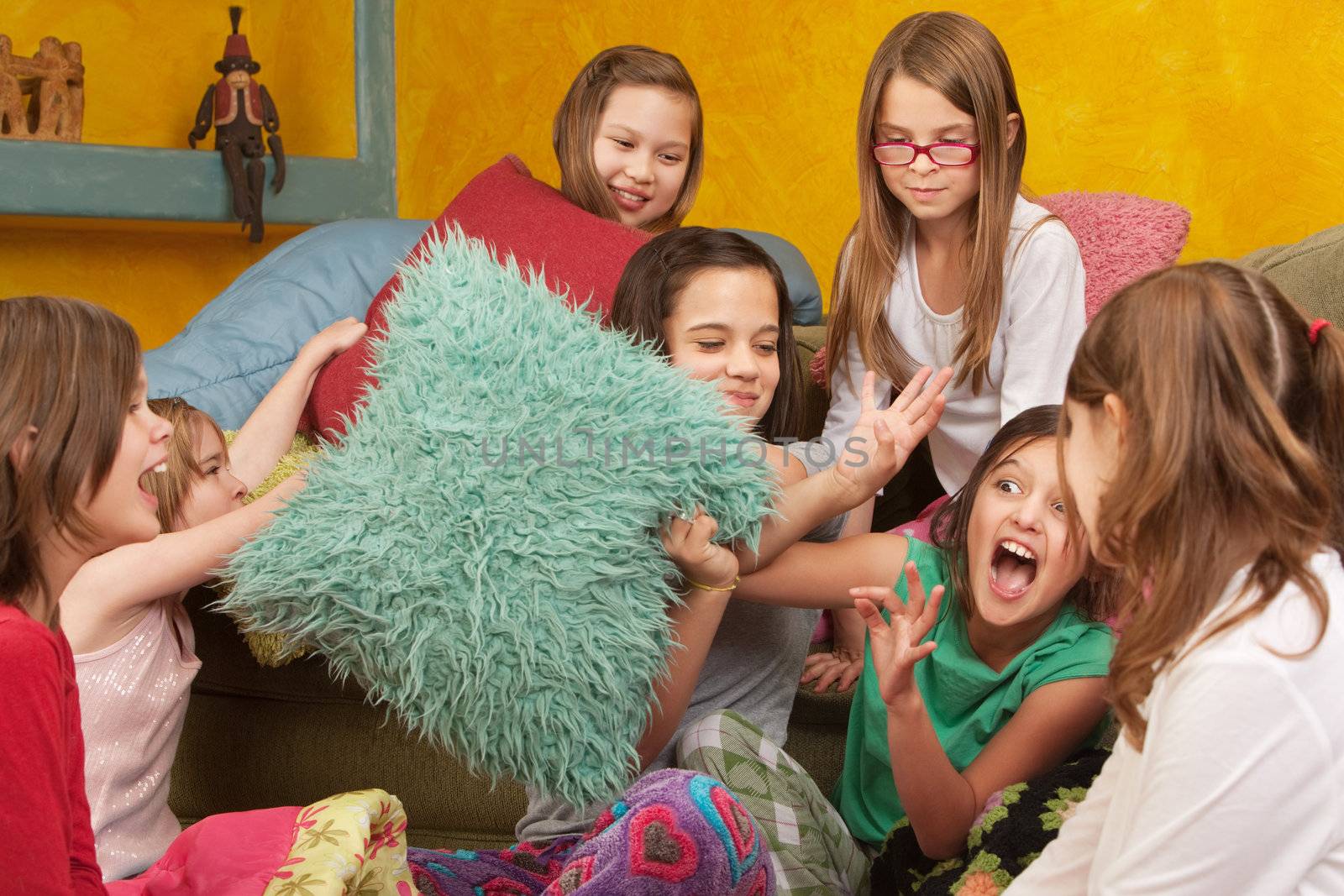 Pillow-fighting among seven girls at a sleepover