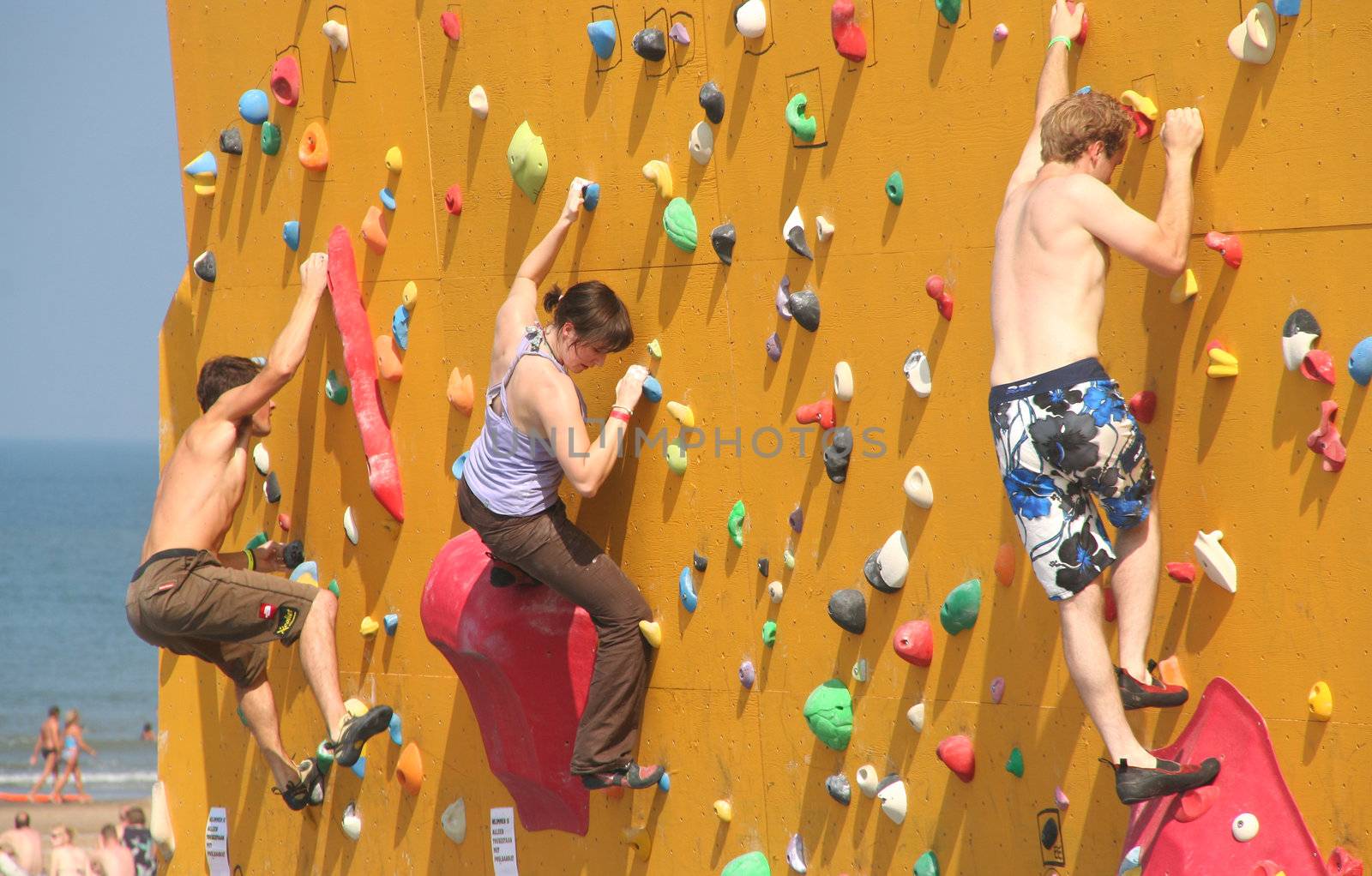 Annual Bouldering Competition on Scheveningen beach. Participants climbing artificial rock face.