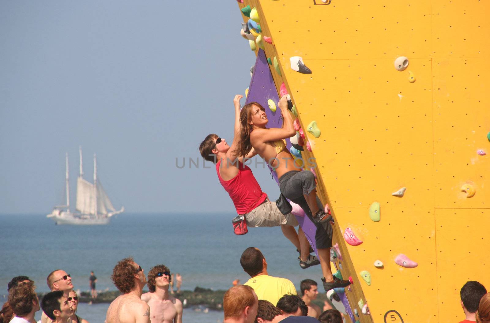 Annual Bouldering Competition on Scheveningen beach. Participants climbing artificial rock face.