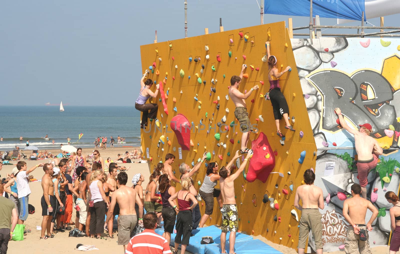 Annual Bouldering Competition on Scheveningen beach. Participants climbing artificial rock face.