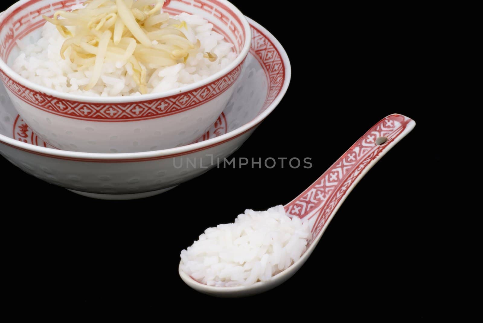 Chinese bowl with rice against black background.