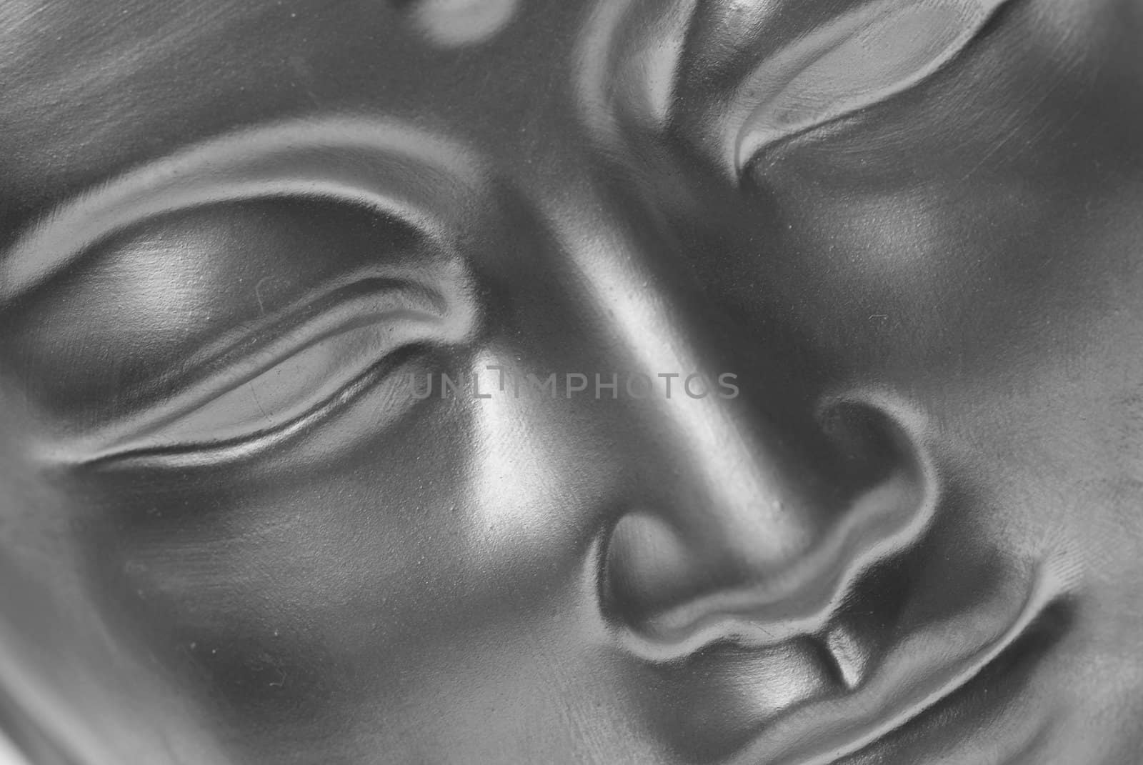 Close up of the face of a buddha in black and white.