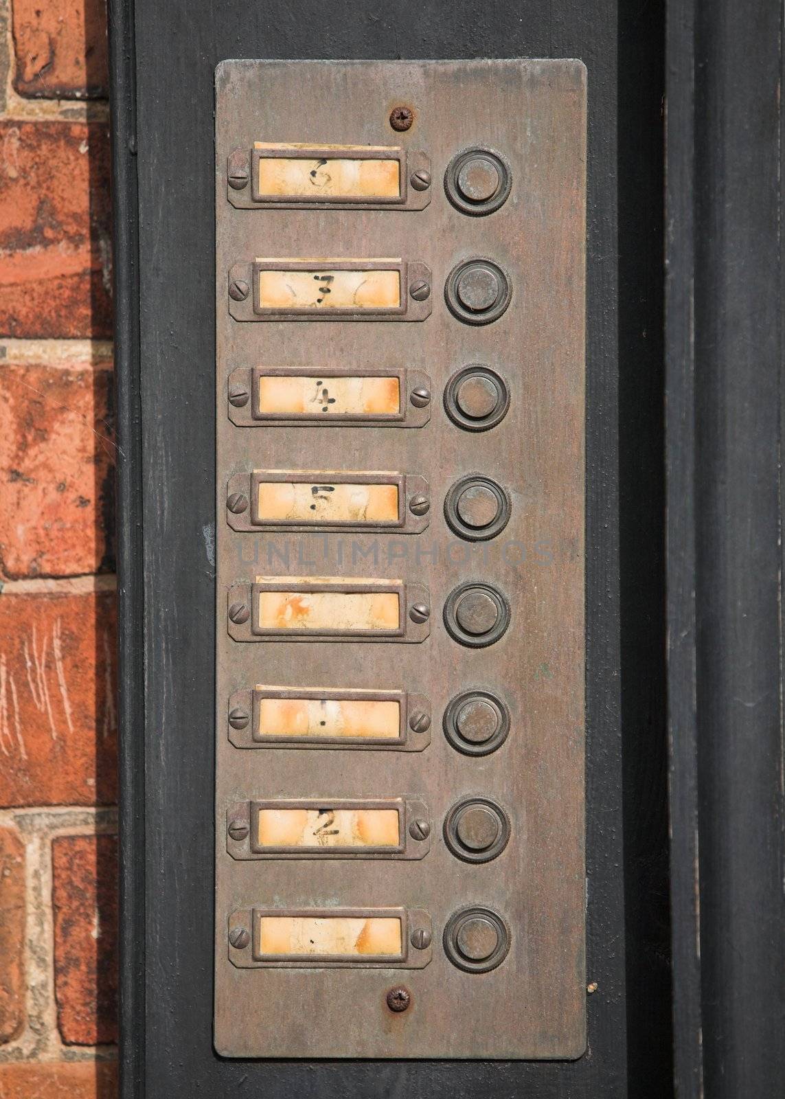 Row of numbered door bell buttons on a wall
