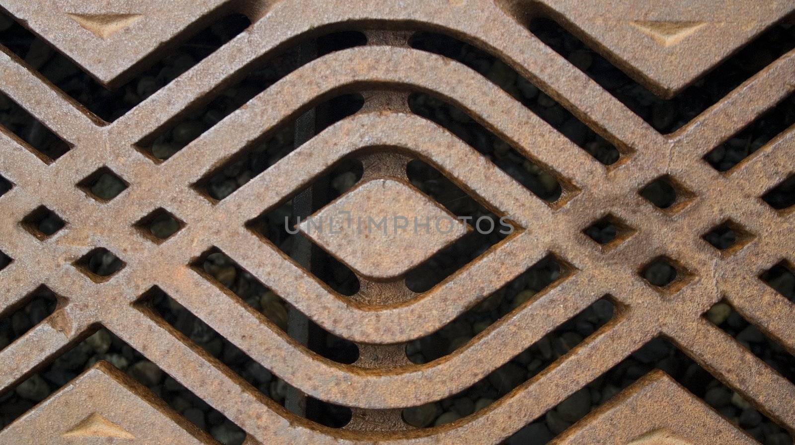 A rusty metal grate with a modern pattern.