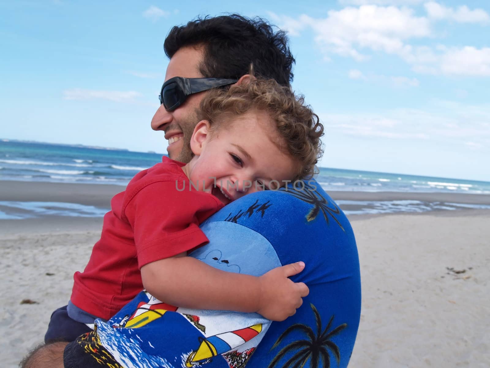 Father holds son on shoulder.