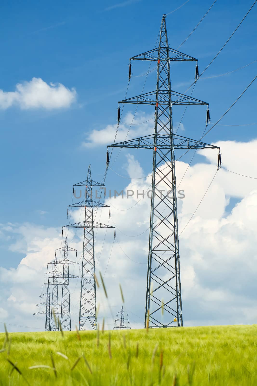 high voltage power lines against a blue sky by artush
