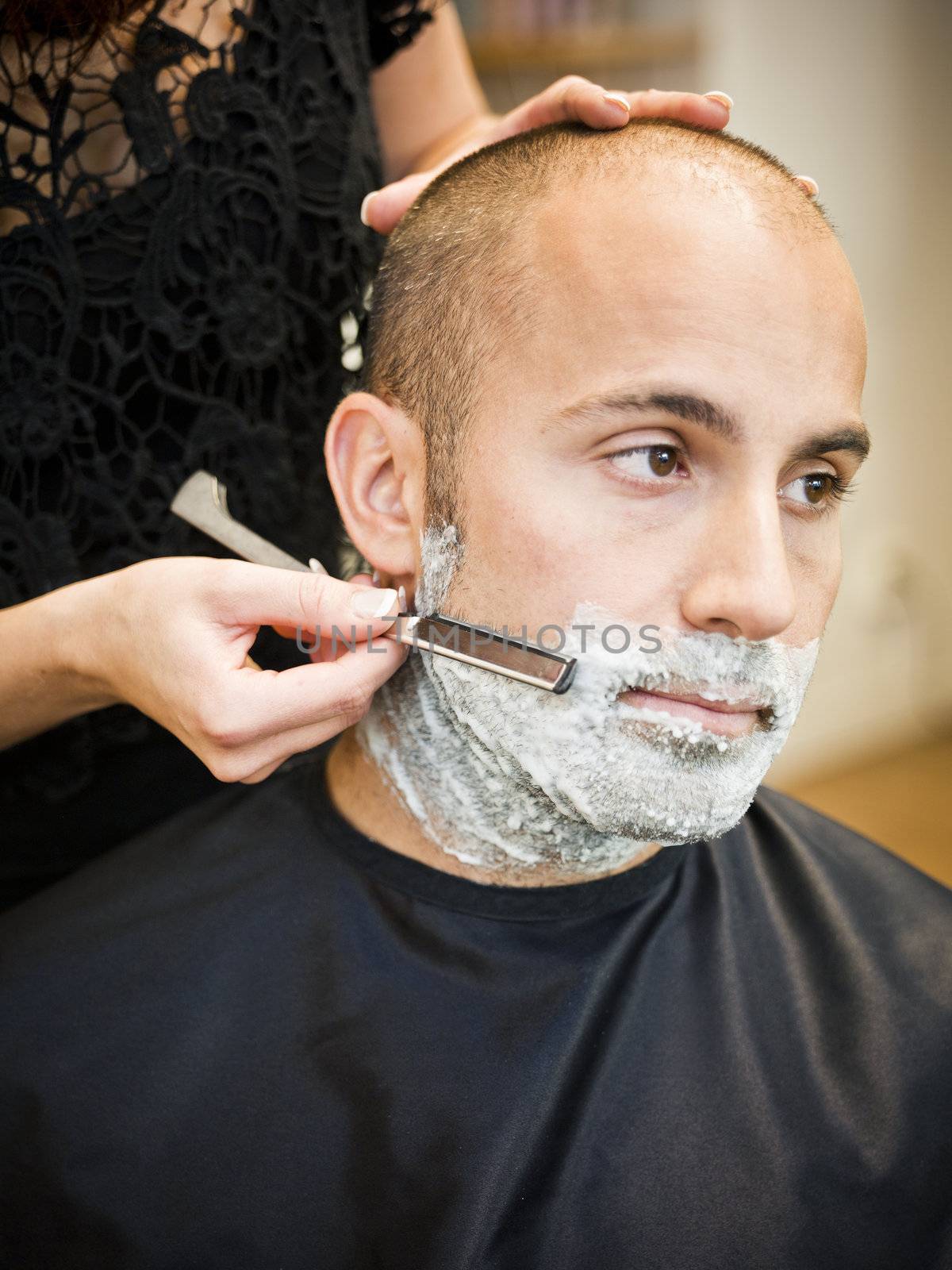 Adult man being shaved at the hair salon