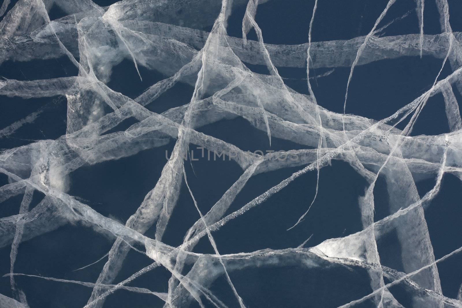 Network of cracks in thick solid layer of ice of a frozen lake due to stress caused by temperature changes.