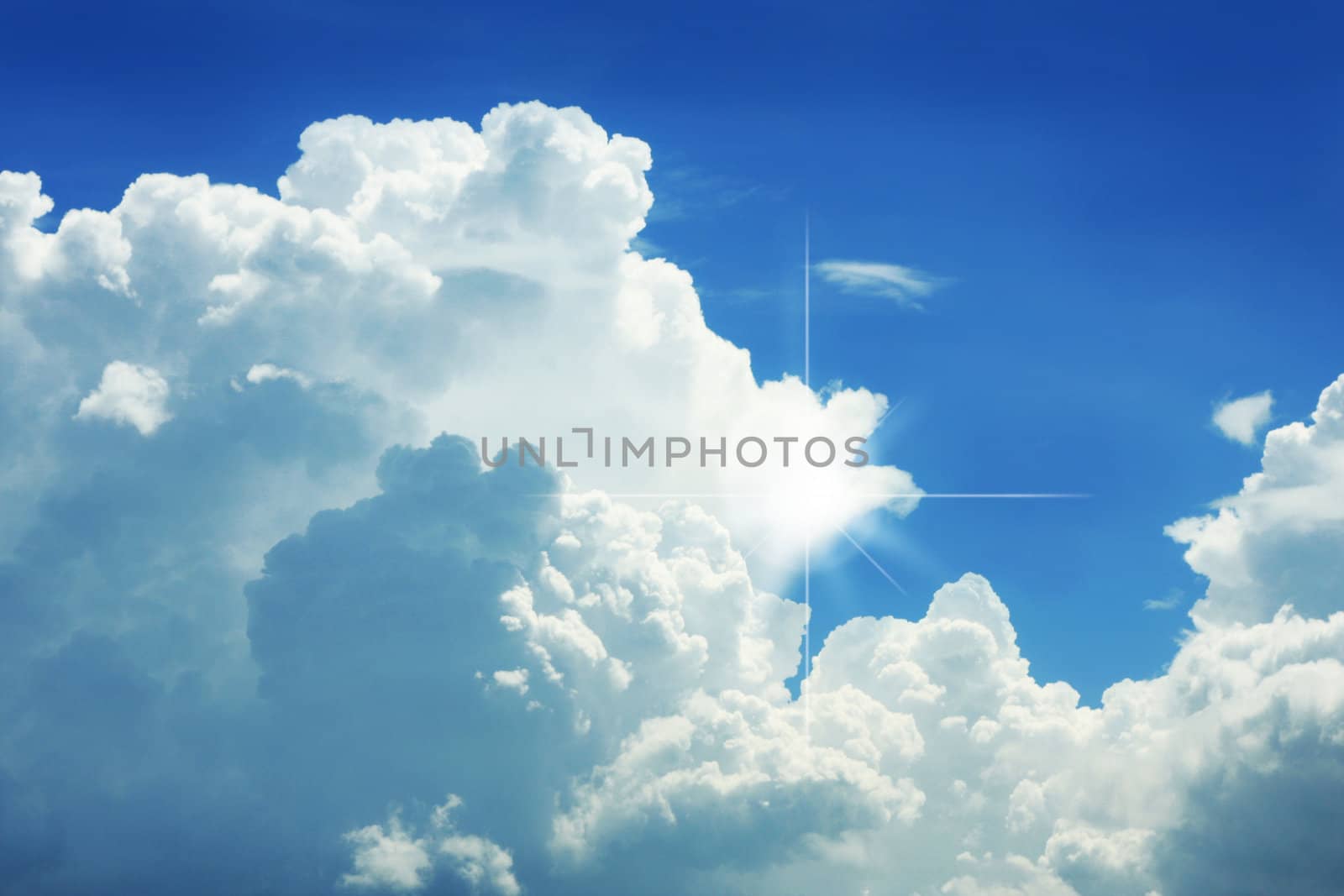 Dramatic blue sky with white clouds and a sunrays.