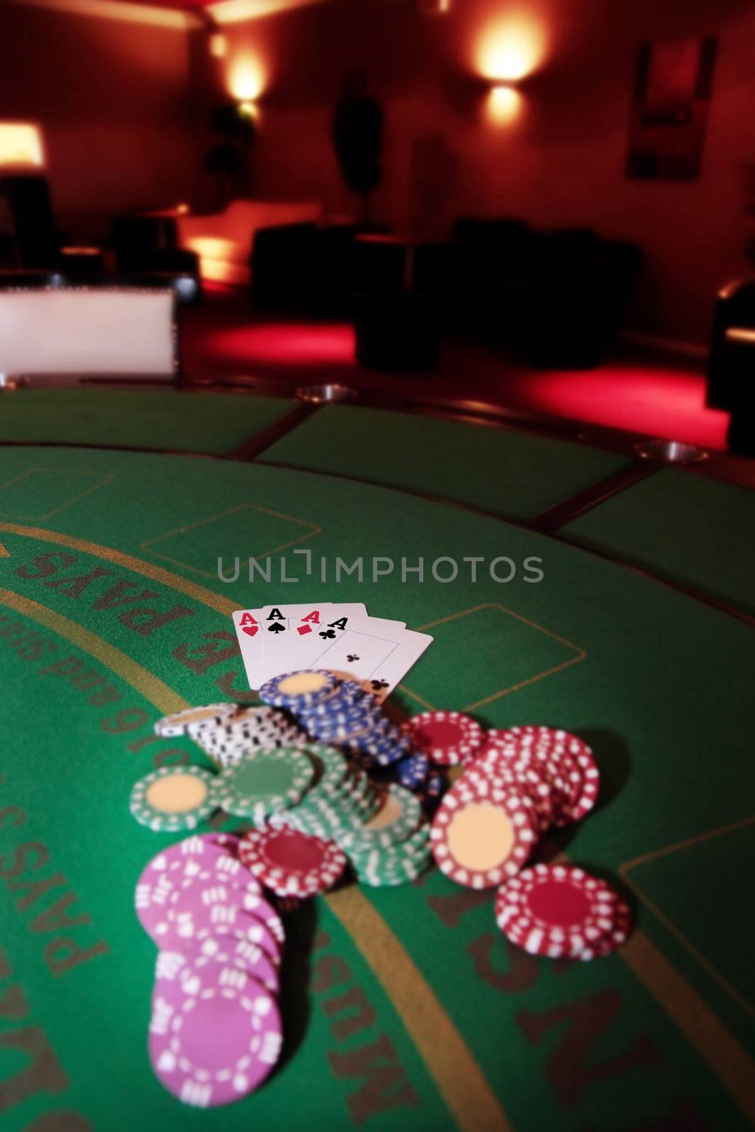 green casino table four aces in a poker game and a big pile of chips