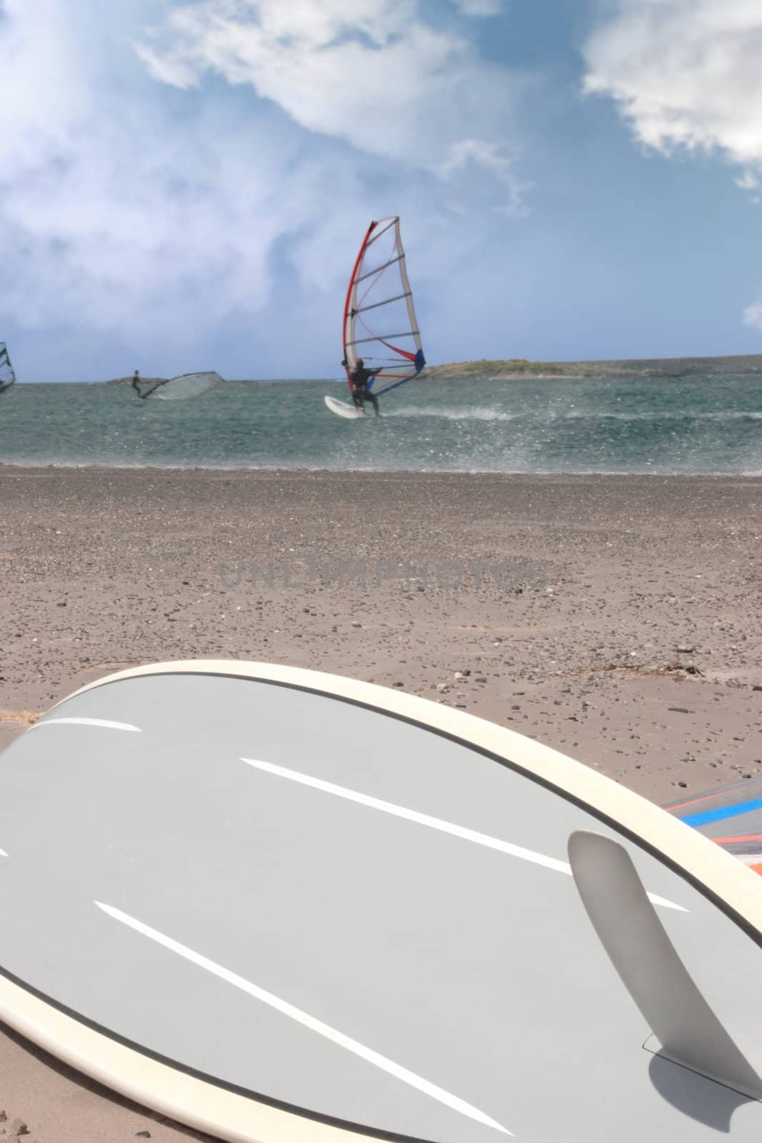 surfboard and surfers windsurfing in a storm by morrbyte