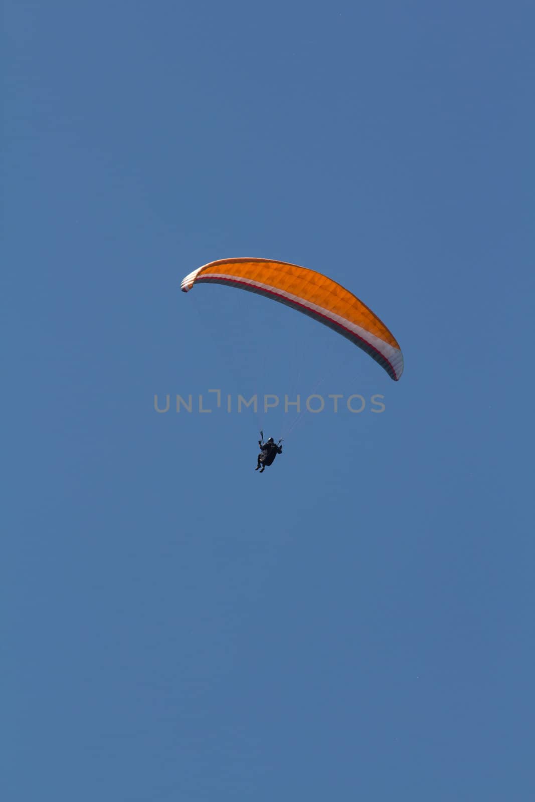 A Paraglider flying from a mountain on a warm summer afternoon