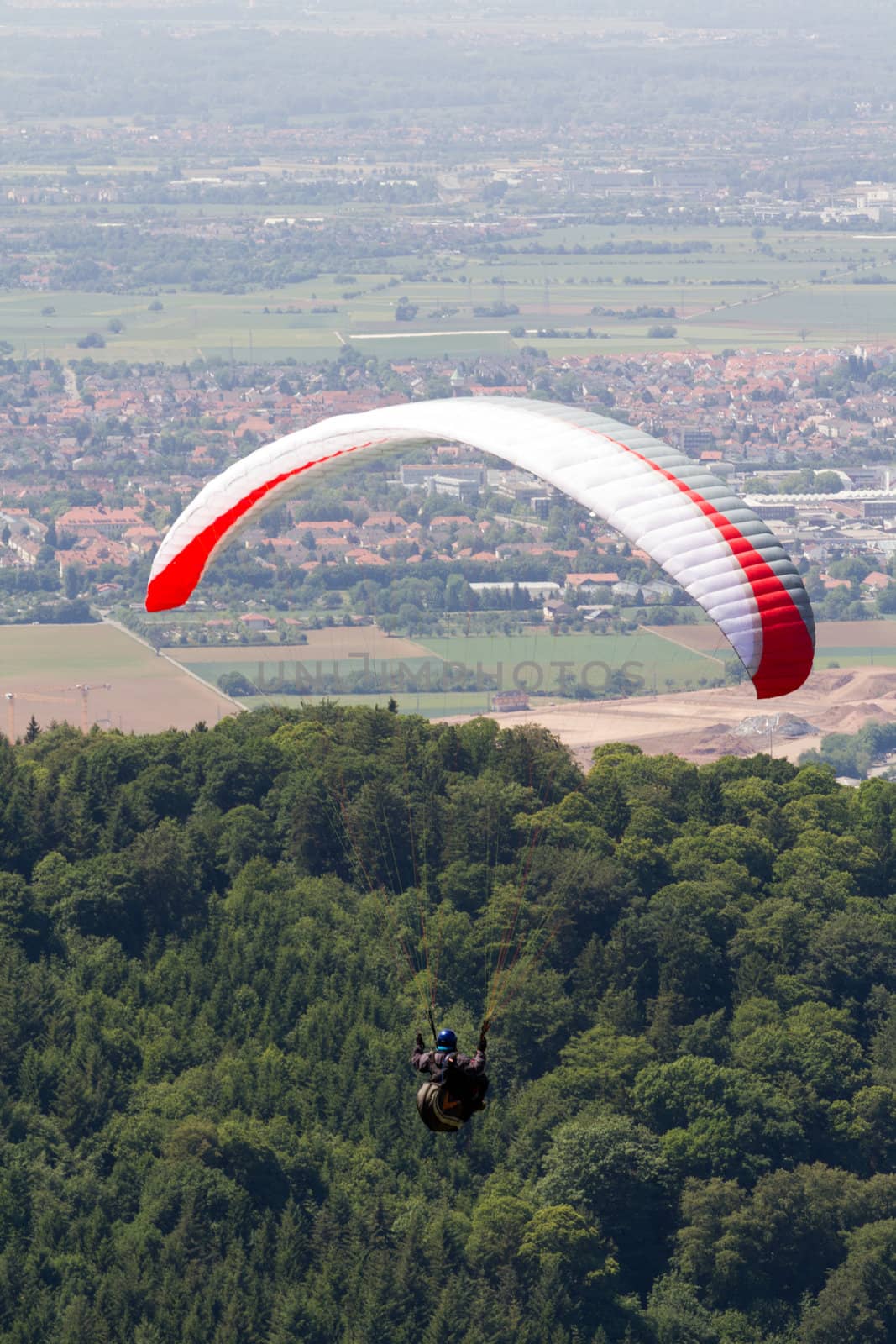 A Paraglider flying from a mountain on a warm summer afternoon
