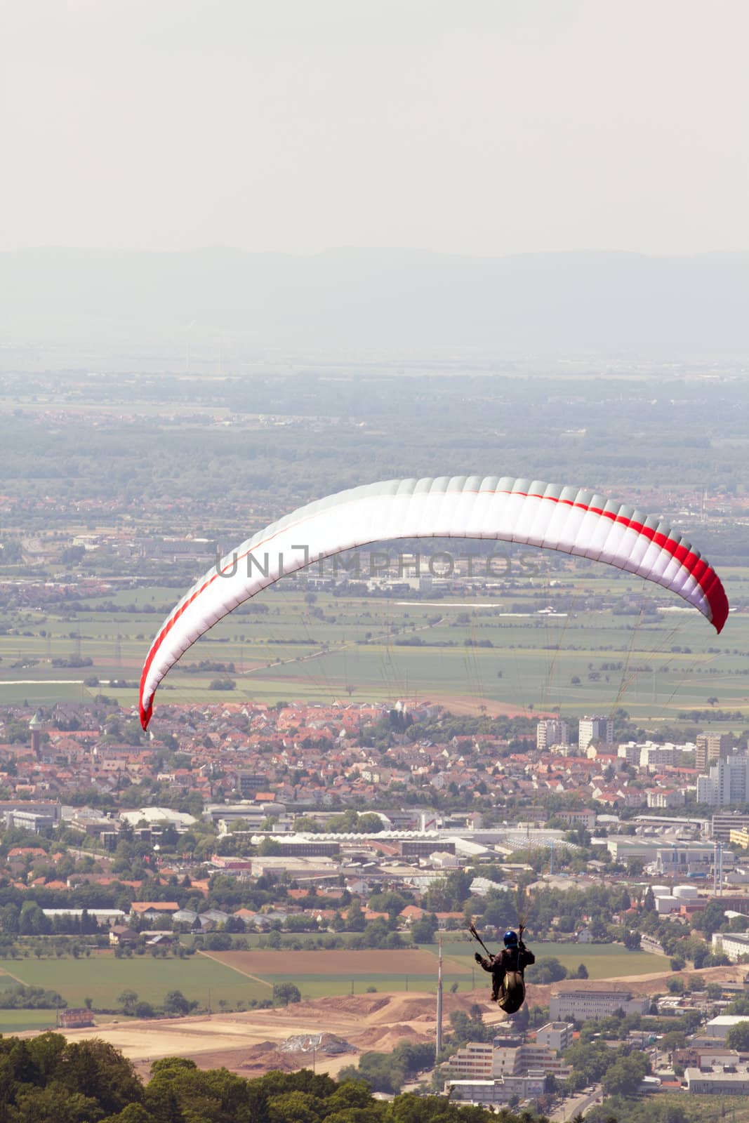 A Paraglider flying from a mountain on a warm summer afternoon