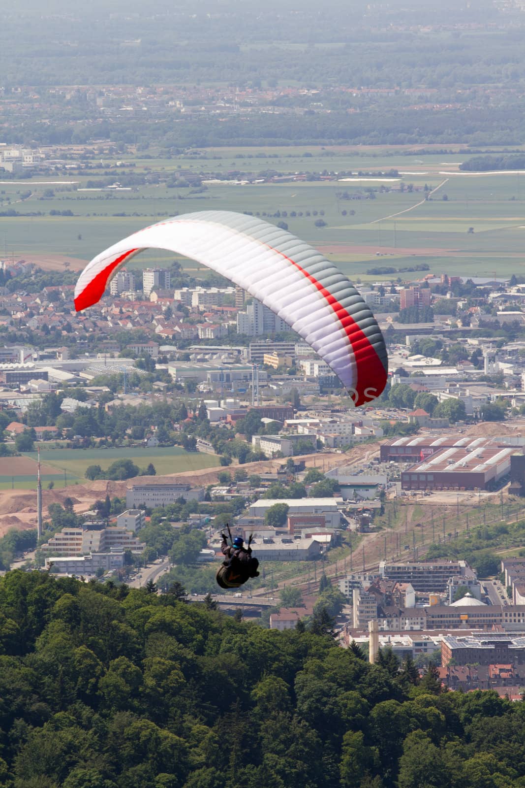 A Paraglider flying from a mountain on a warm summer afternoon