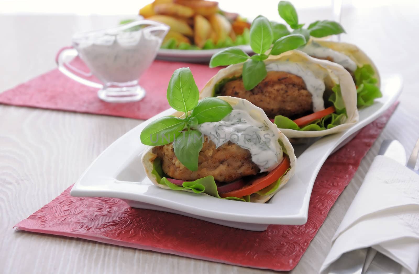 Patty in pita bread with cream sauce and vegetables by Apolonia