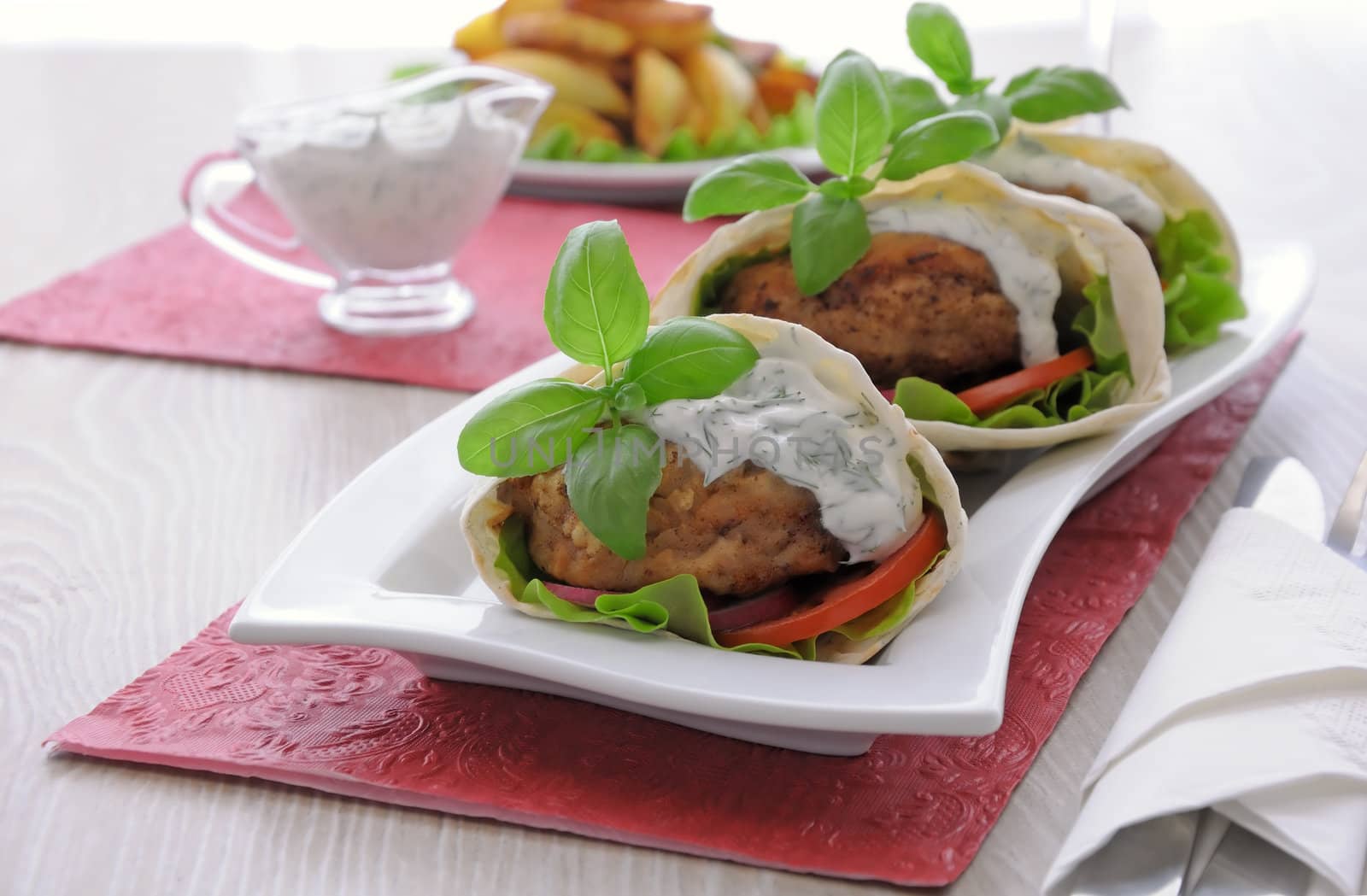 Patty in pita bread with vegetables in cream sauce