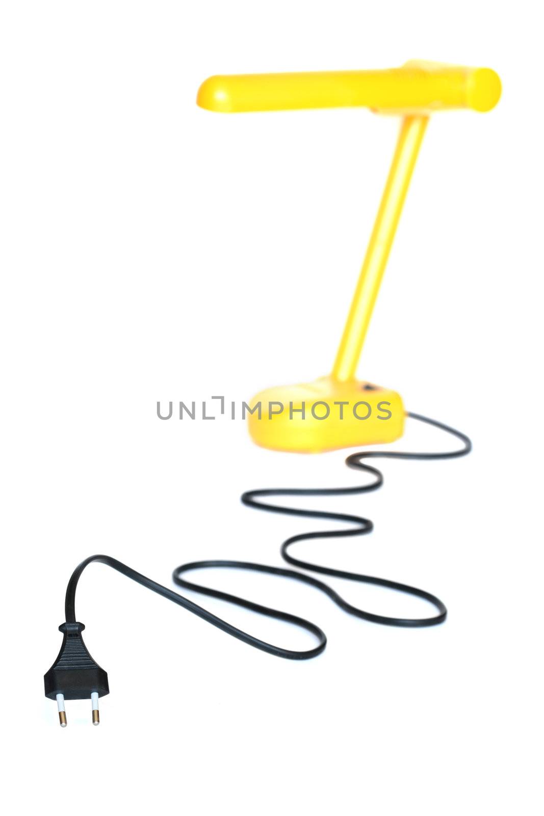 Electric plug with long black cable and yellow desk lamp on white background