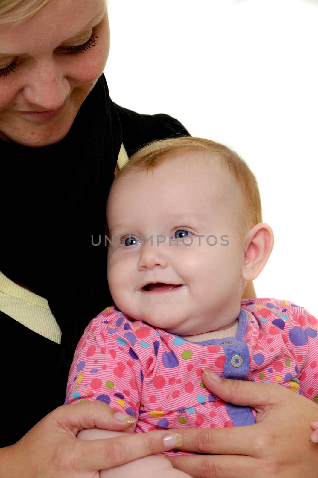 Mother is looking down on her sweet smiling baby. Taken on a white background.