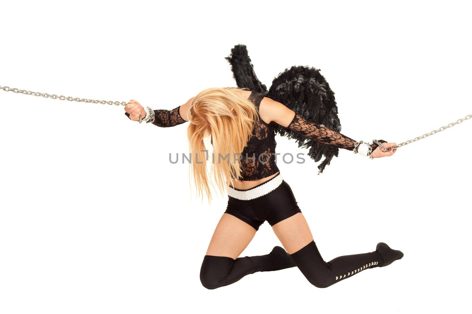 Model in role of black angel trying to break chains