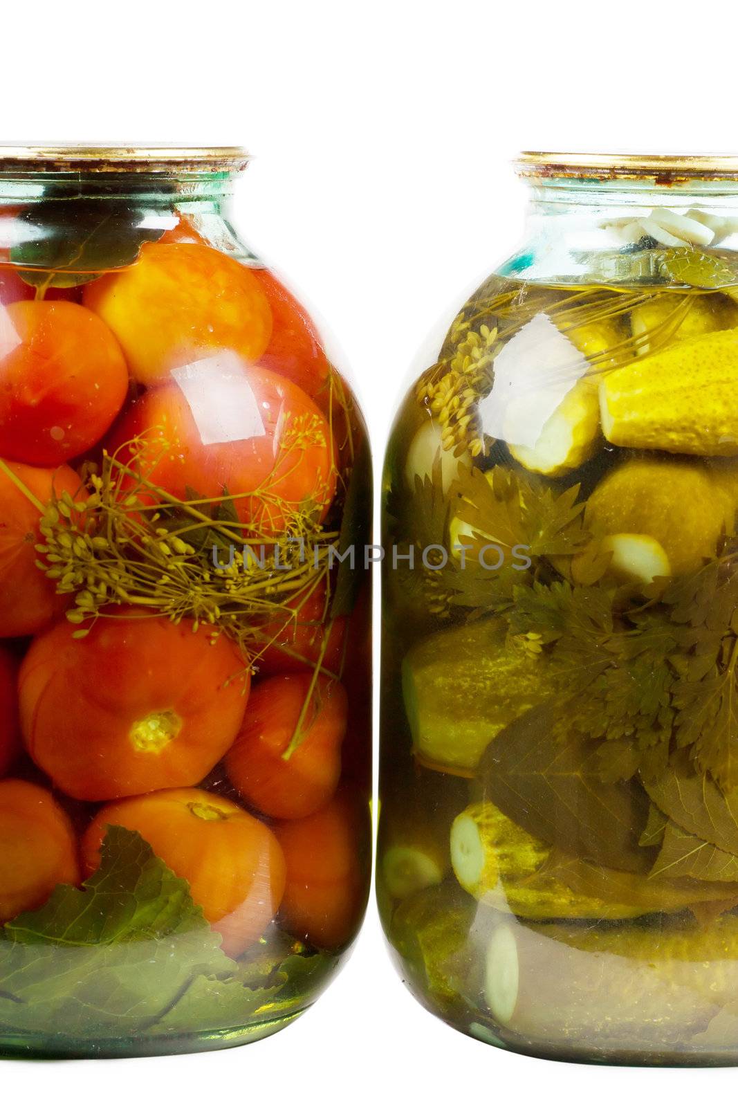 Two jars of pickles and tomatoes isolated over white background