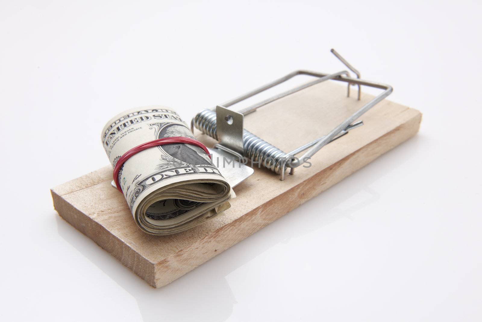 several dollar bills with elastic band  set on a mouse-trap
