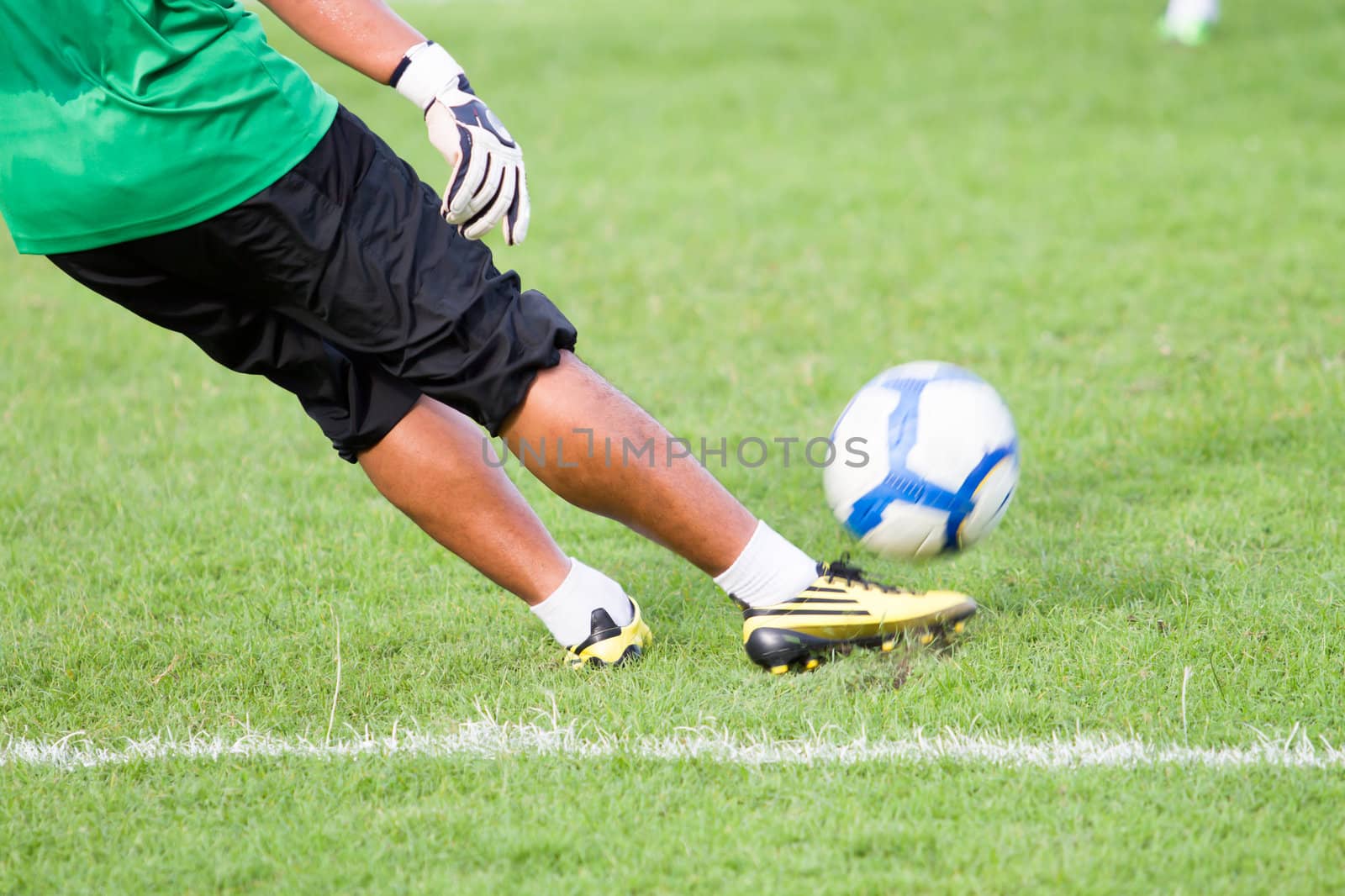 Soccer player kicking ball by Suriyaphoto