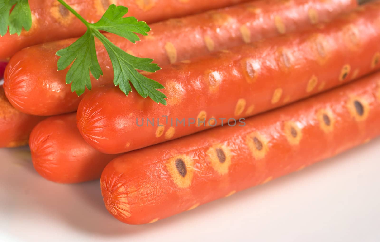 Sausages garnished with a parsley leaf (Selective Focus, Focus on the front of the sausages)
