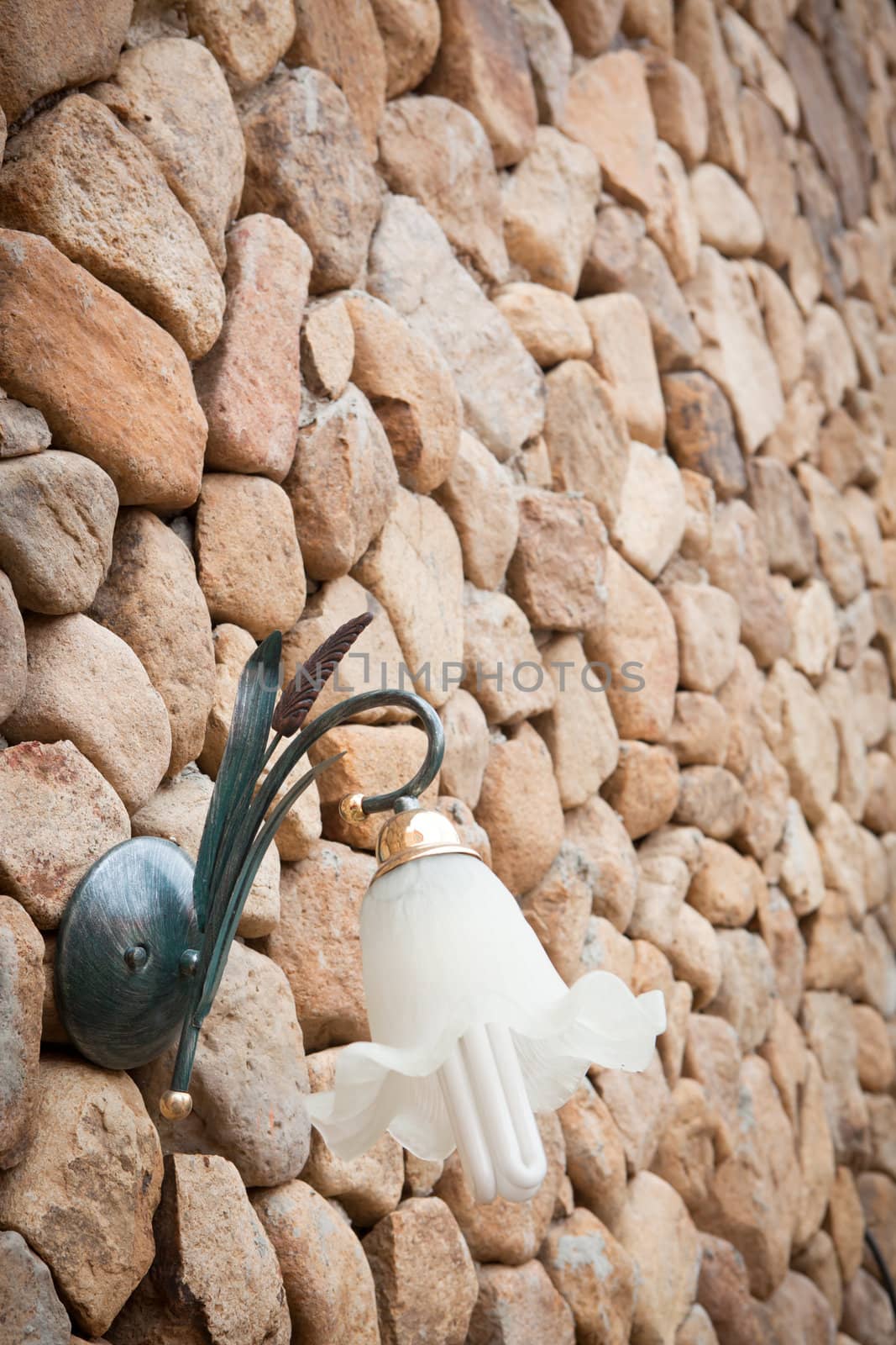 Wall lamp on stone wall by Suriyaphoto