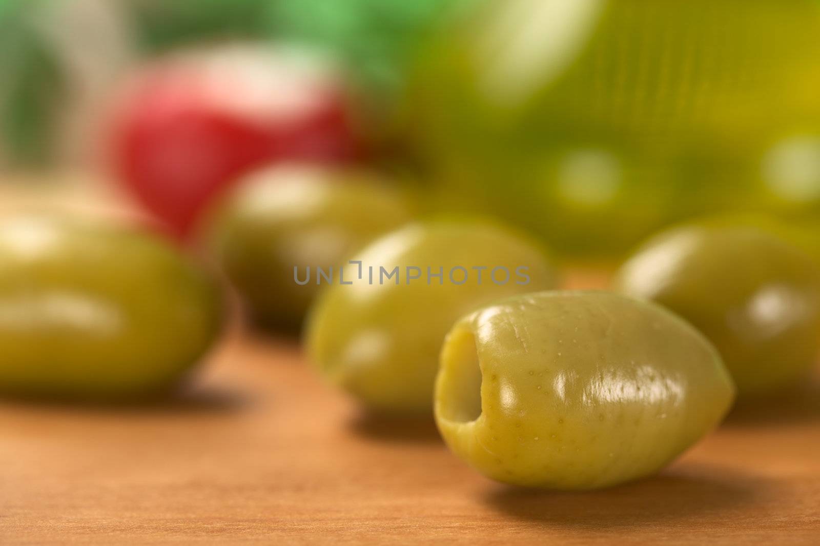 Green olive with olive oil in the back (Very Shallow Depth of Field, Focus on the front close to the opening of the right olive)