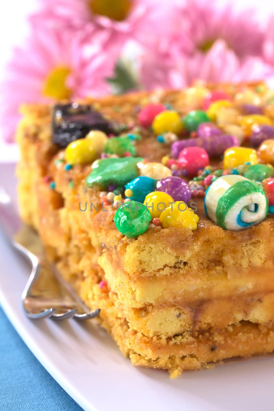 Peruvian colorful cake called Turron flavored with anis, sesame, dried fruits and honey and garnished with colorful sweets on top (Selective Focus, Focus on the front tip and the green ball on top)