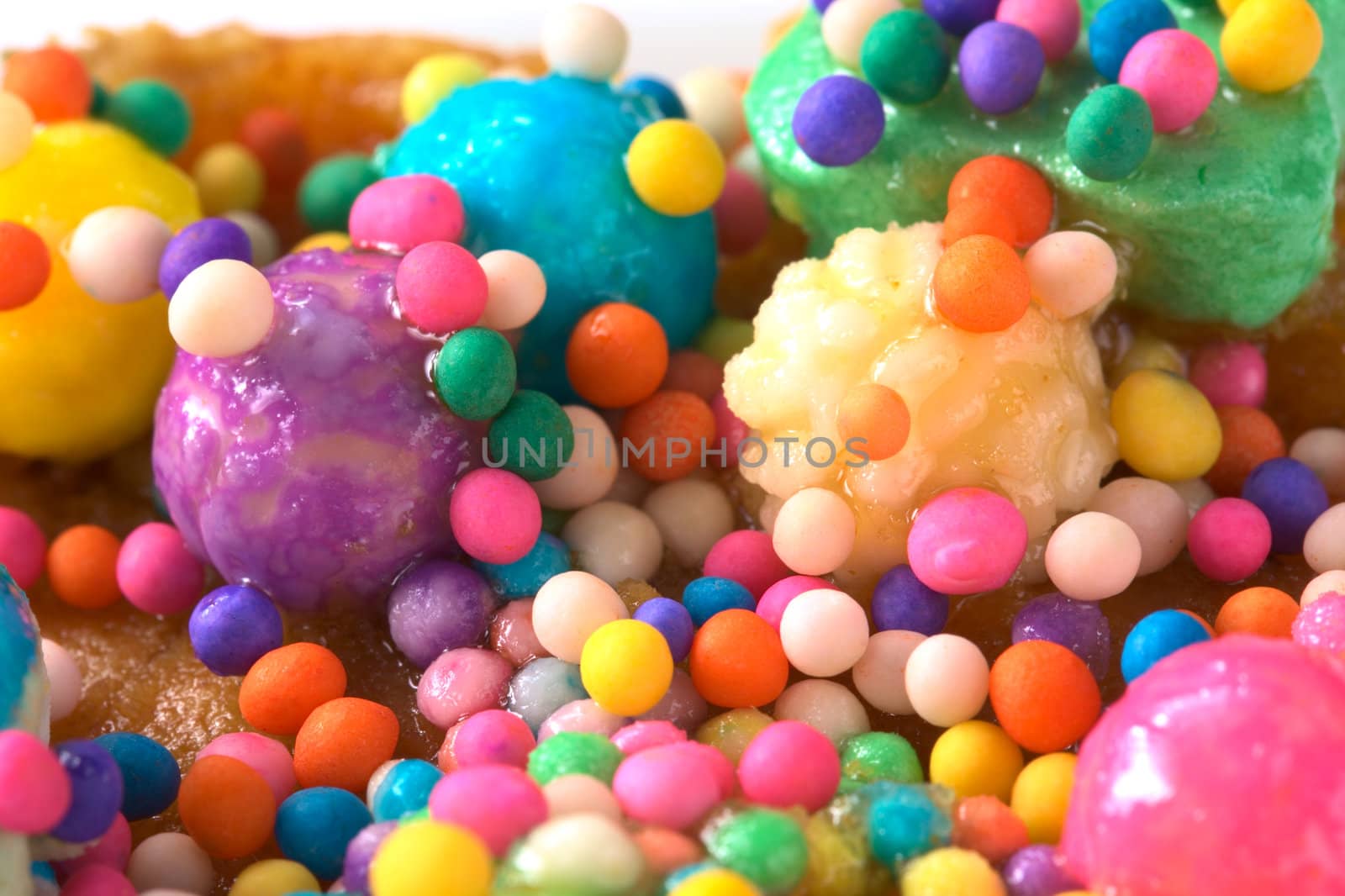 Colorful sweet candy balls garnishing the Peruvian cake called Turron (Selective Focus, Focus on the big light ball in the top right corner and several other small ones)