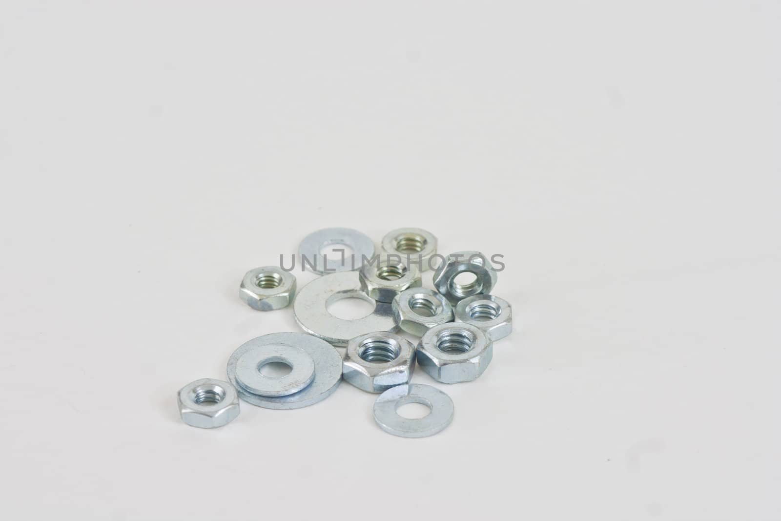 A pile of assorted nuts and washers on a white background.
