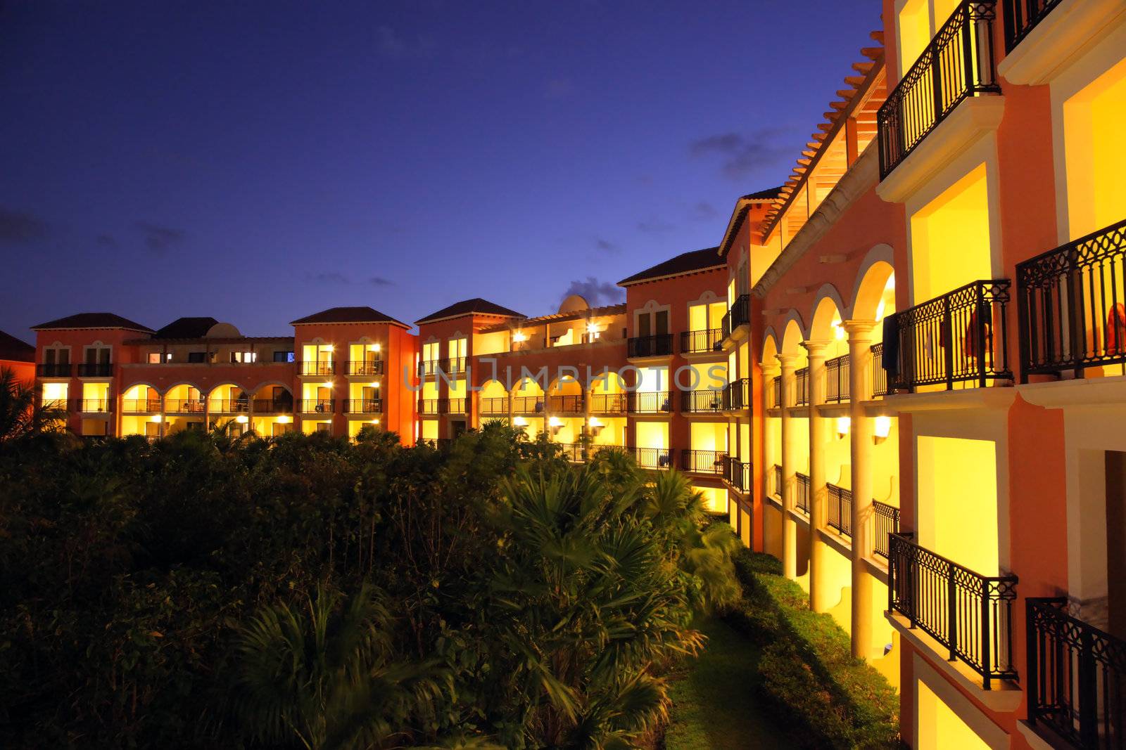 Gorgeous tropical five stars resort at sunset with all the rooms with balconies lit up.
