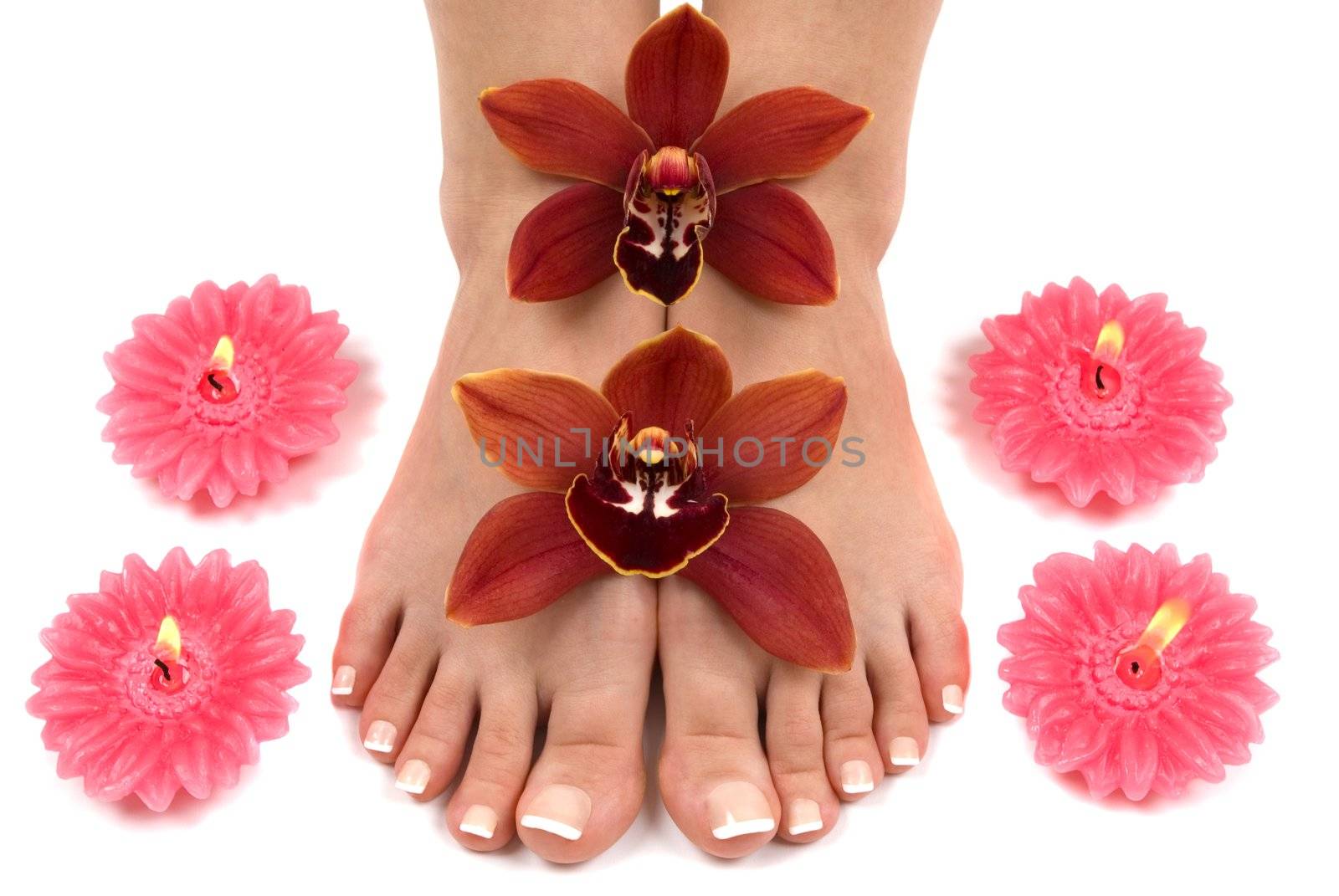 Feet with beautiful fresh orchids and candles