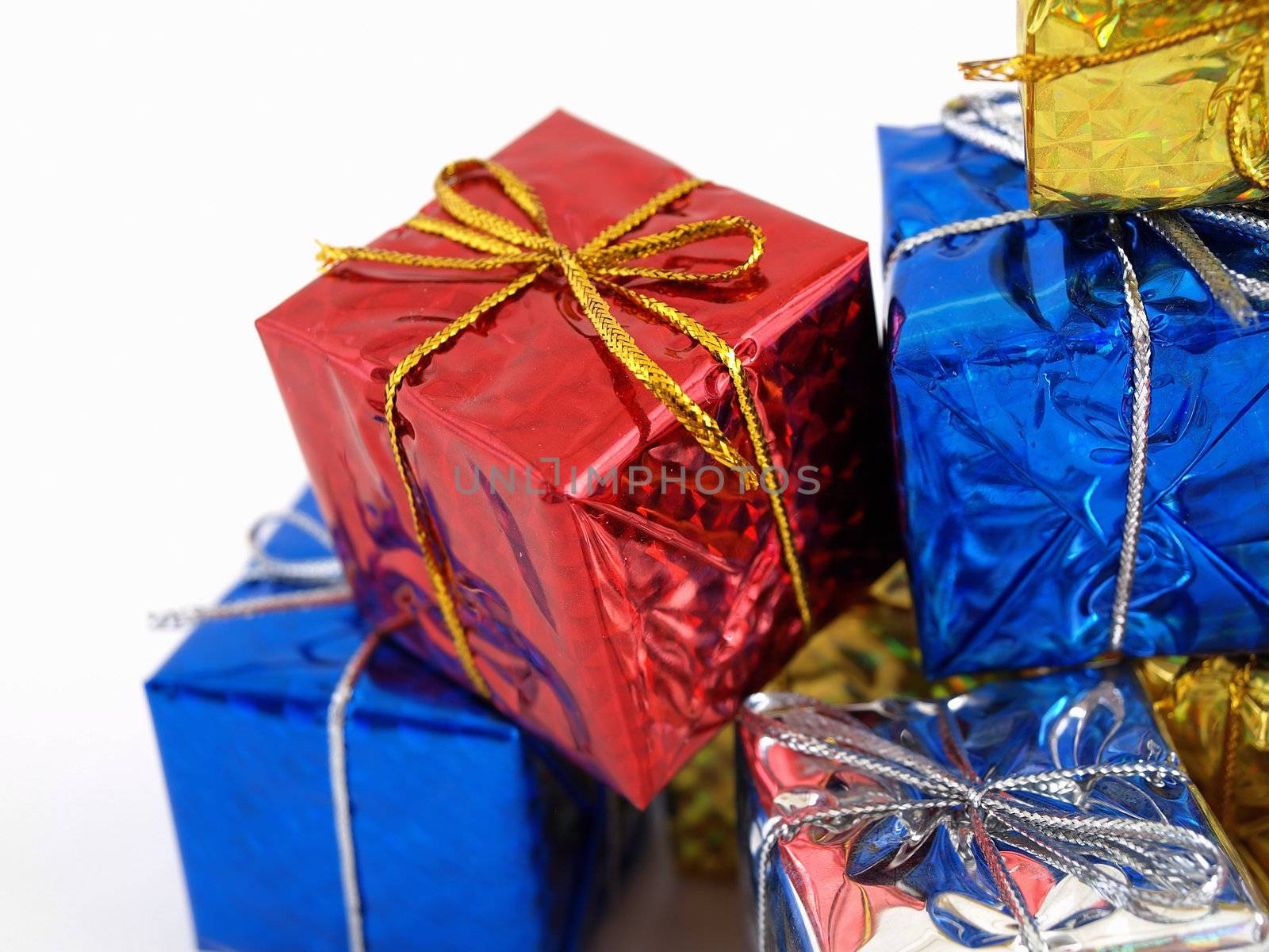 Colorful gift boxes in shiny wrapping paper isolated against a white background.