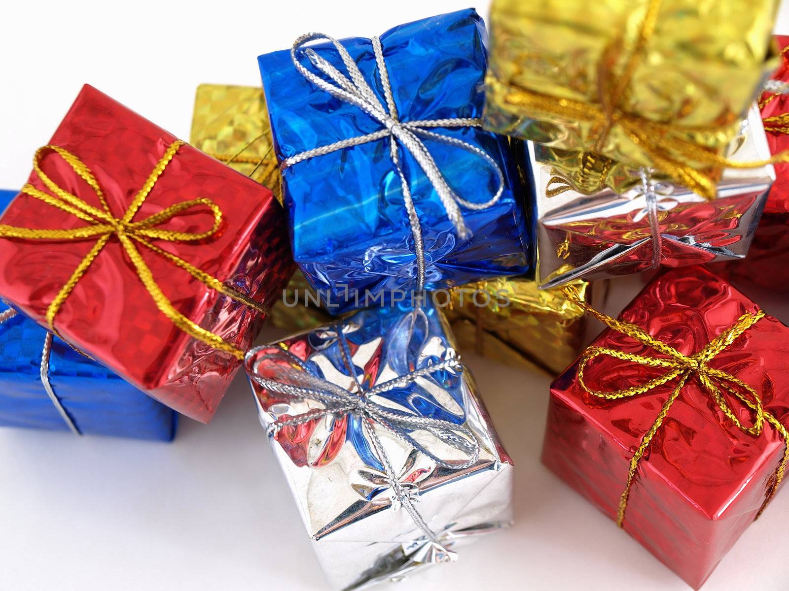 Colorful gift boxes in shiny wrapping paper isolated against a white background.