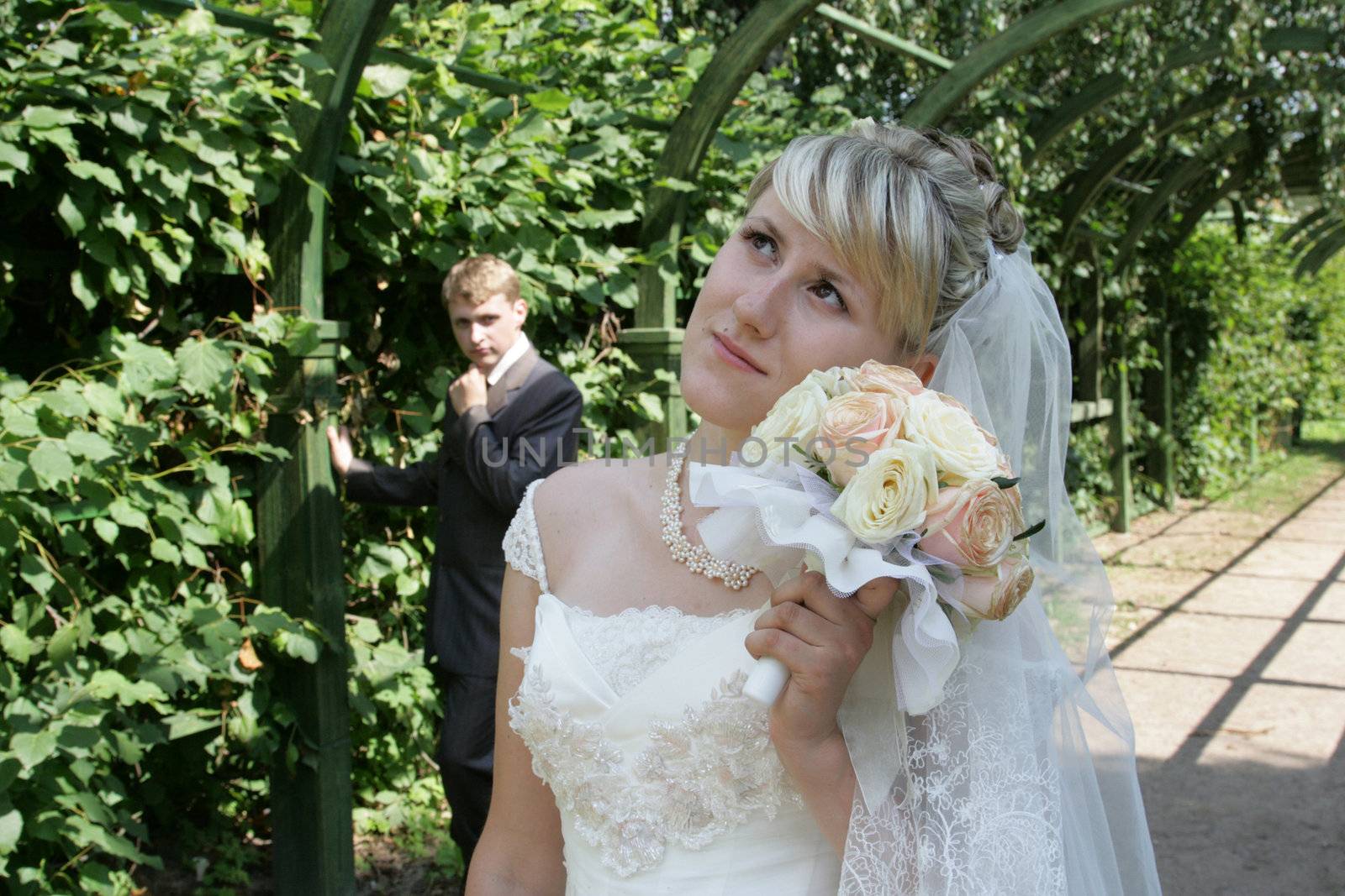 The groom and the bride walk in park in the summer