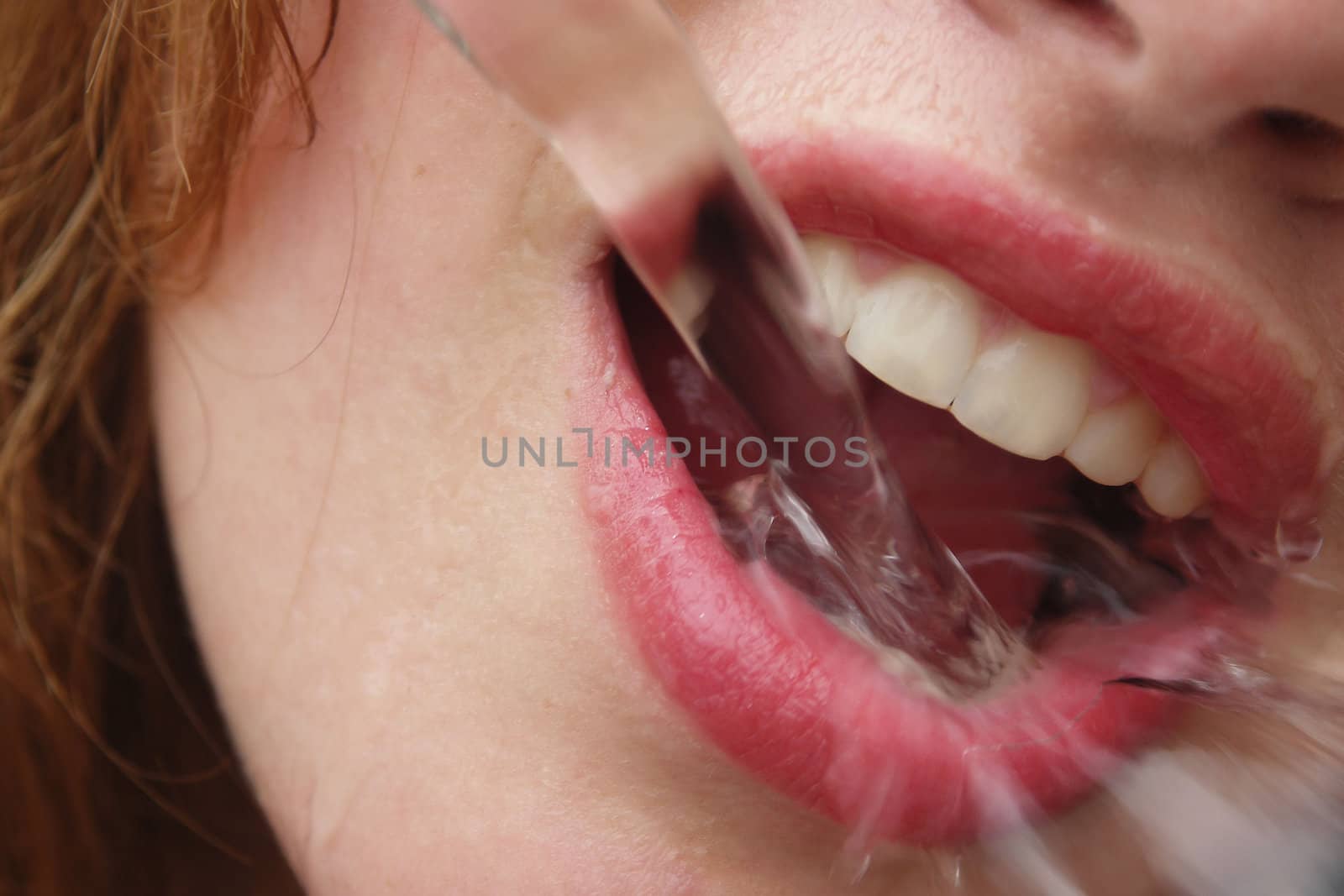 Water pouring in a girls mouth.
