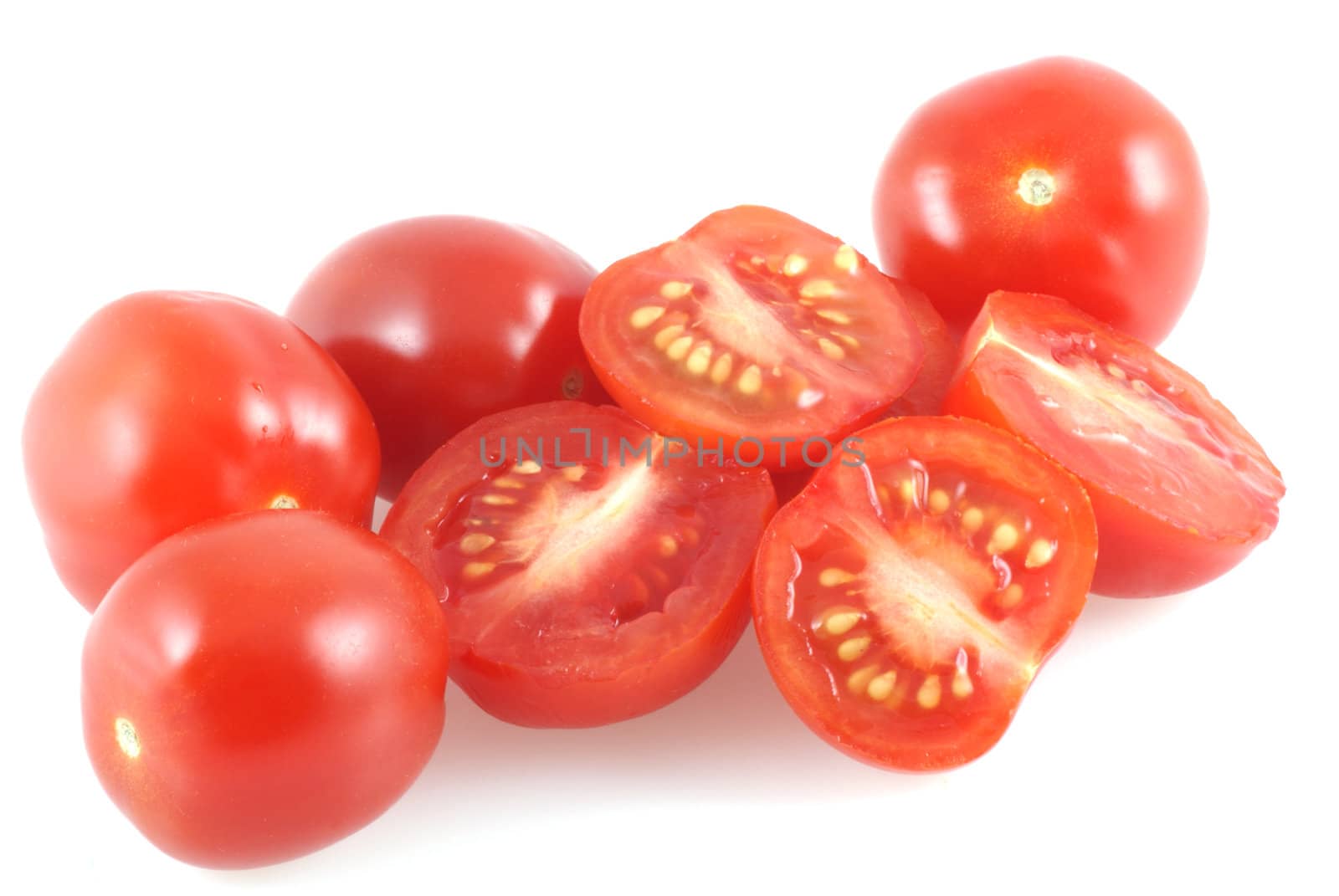 Cherrytomatoes isolated on white and few of them are cut in half.