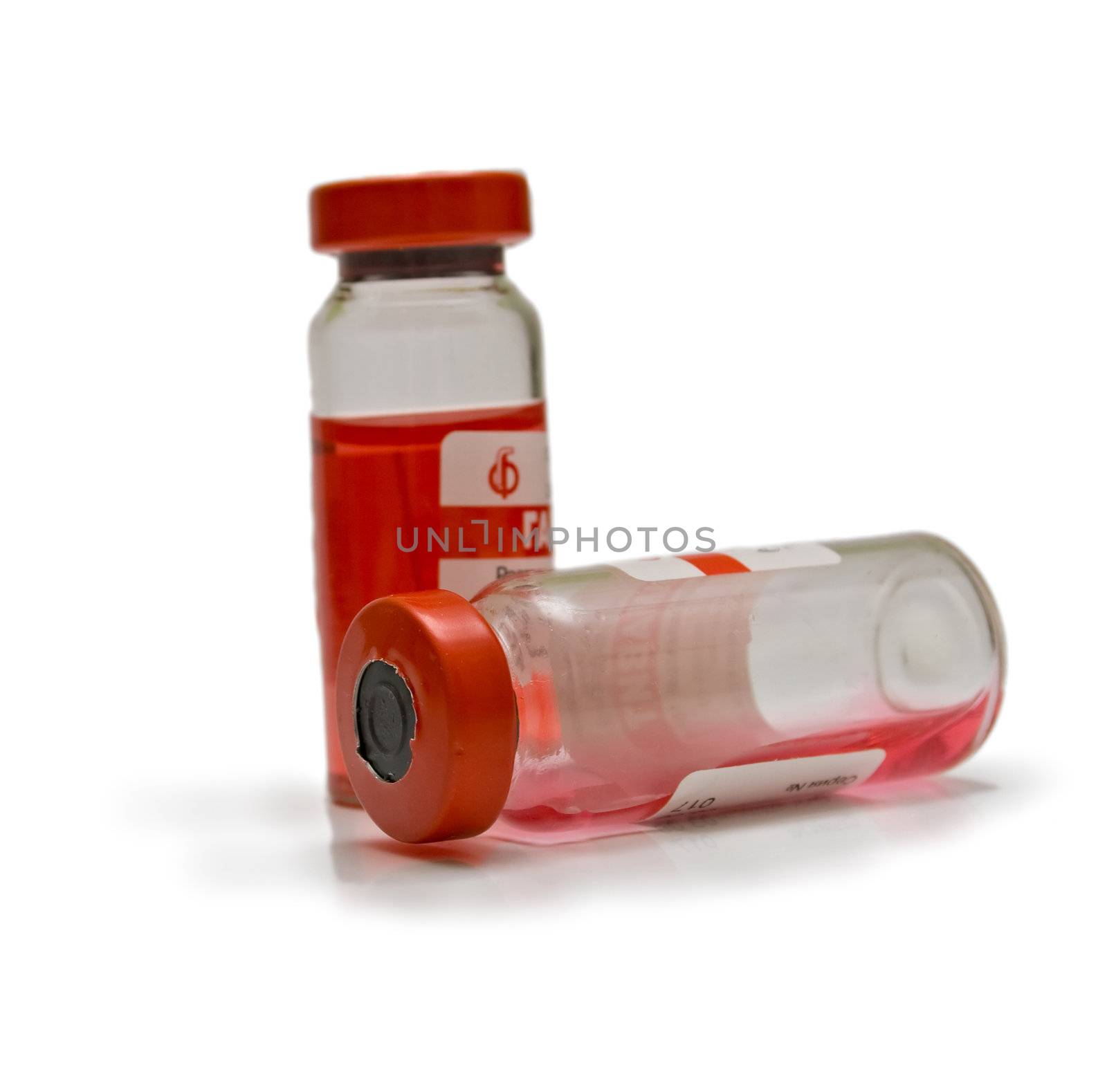 Transparent ampoules with a red medicine on a white background. Isolation. Shallow DOF