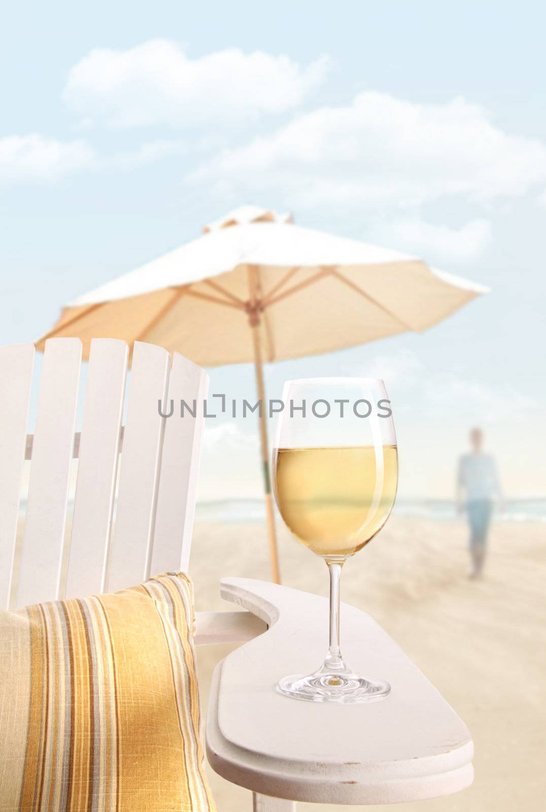 Glass of white wine on adirondack chair at the beach