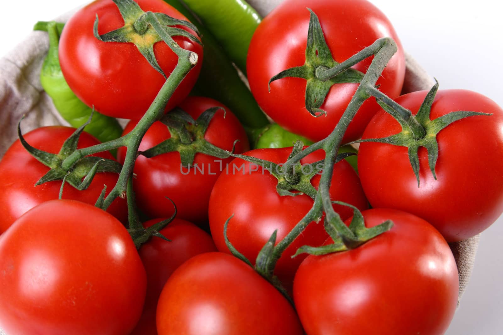 Red tomatoes and green peperoni on white background